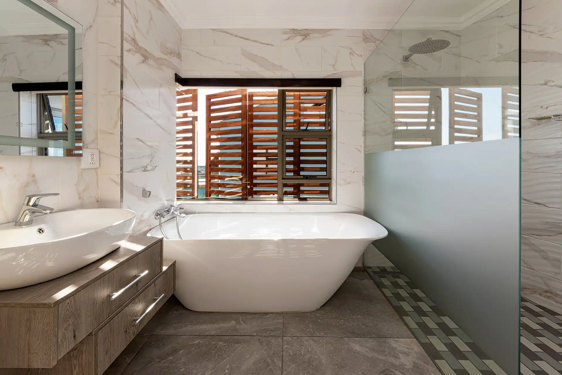Bathroom with a freestanding bath and timber shutters