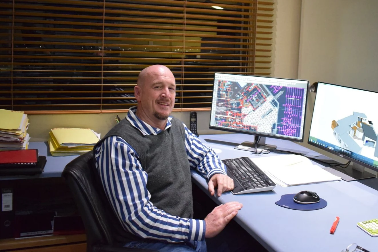 Victor Visagie at his desk with architectural drawings on screen